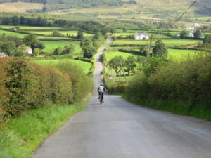 Solo cyclist cycling towards Moville on the Causeway Coast cycling tour with Ireland by Bike