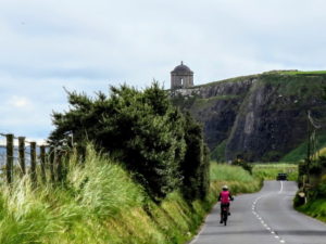 Solo cyclist going towards Mussenden Temple Causeway Coast bike tour with Ireland by Bike cycling tours