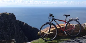 Bicycle leaning against rock with cliffs and sea in the bacground