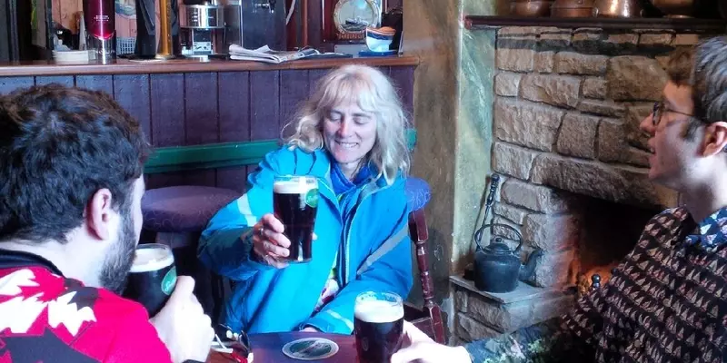 3 people sitting with drinks in a pub setting.
