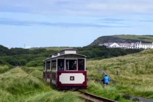 Vintage train with cyclist cycling on a path along the tracks