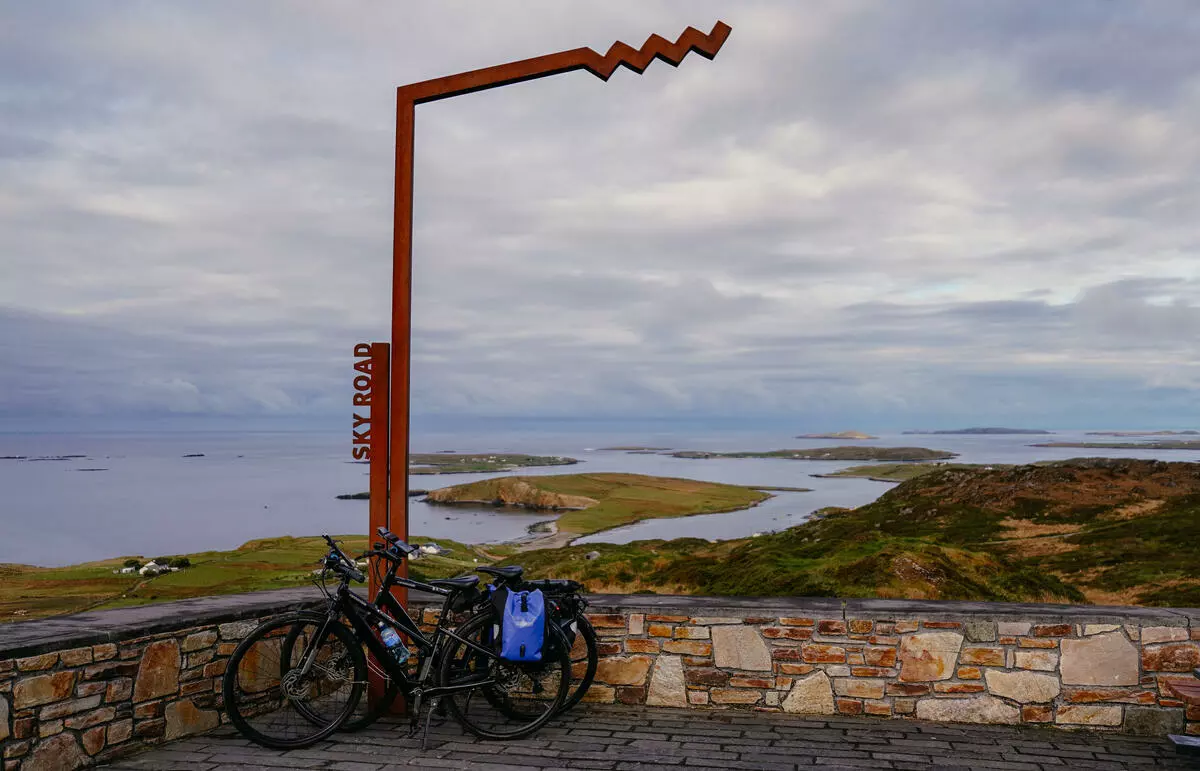 Bicycles beside sign overlooking bay with small islands.