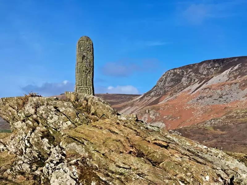 Historic inscribed stone standing on small hilltop